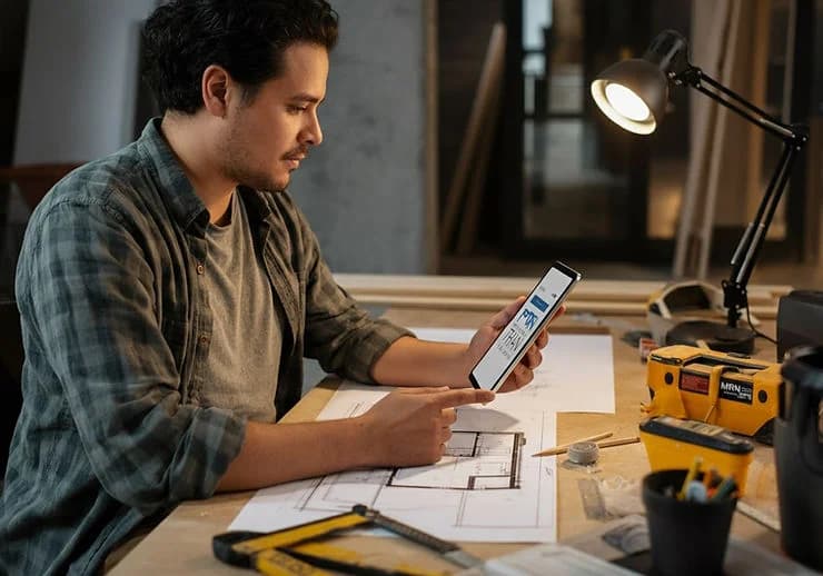 Pessoa planejando reforma com uma calculadora reforma online.